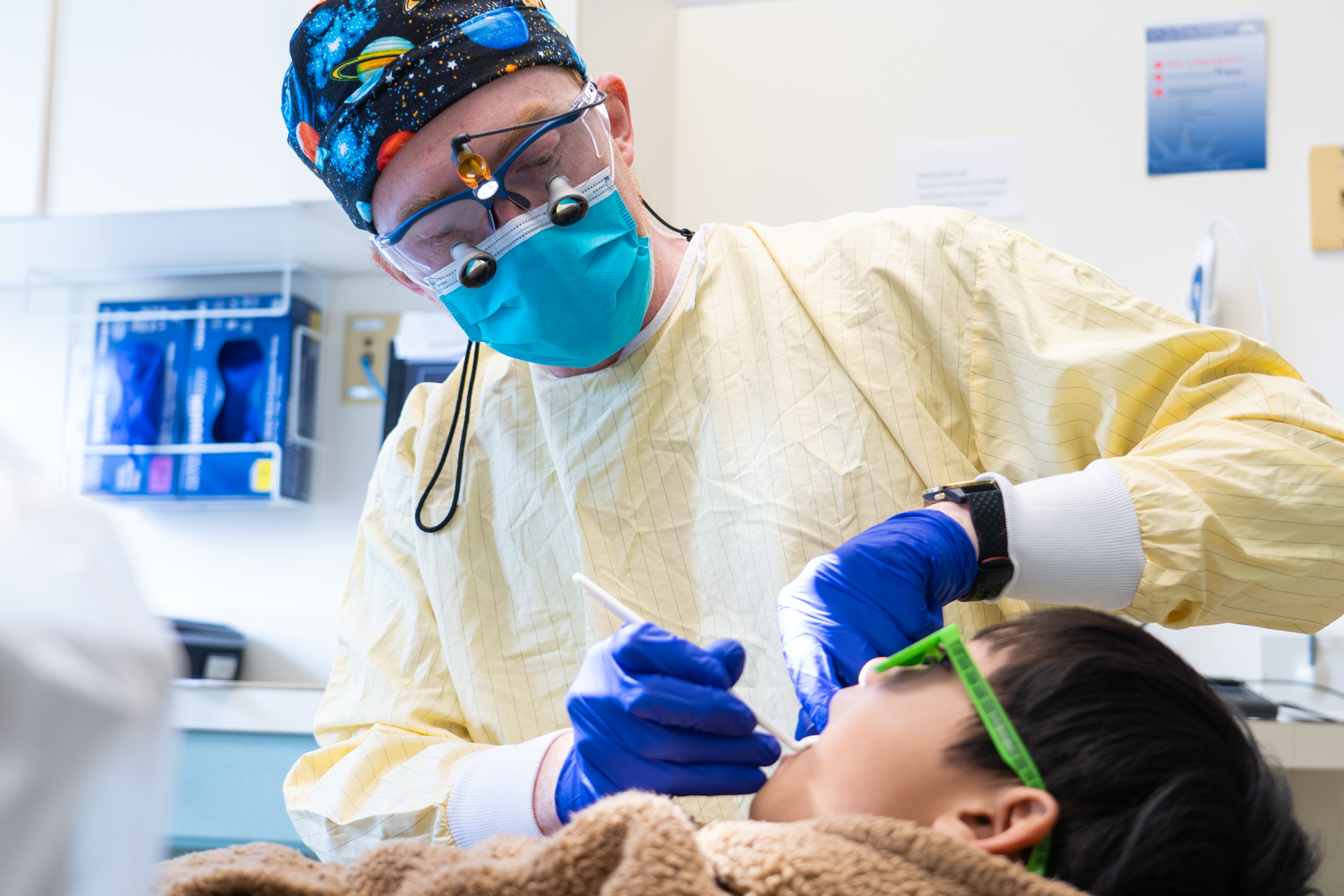 Dentist doing an examination on a boy for Give Kids A Smile Day