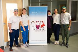 Students standing with popup banner at clinic