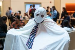 A person draped in a sheet wearing a tie.