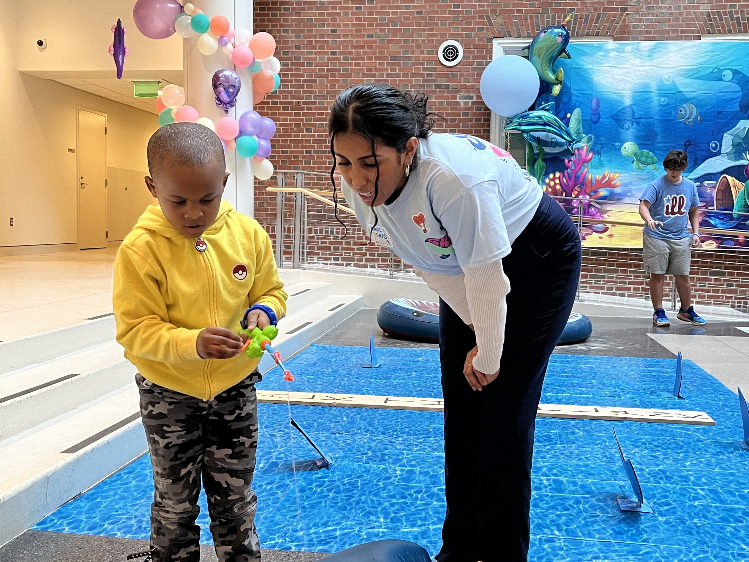 A student playing a fishing game with a patient