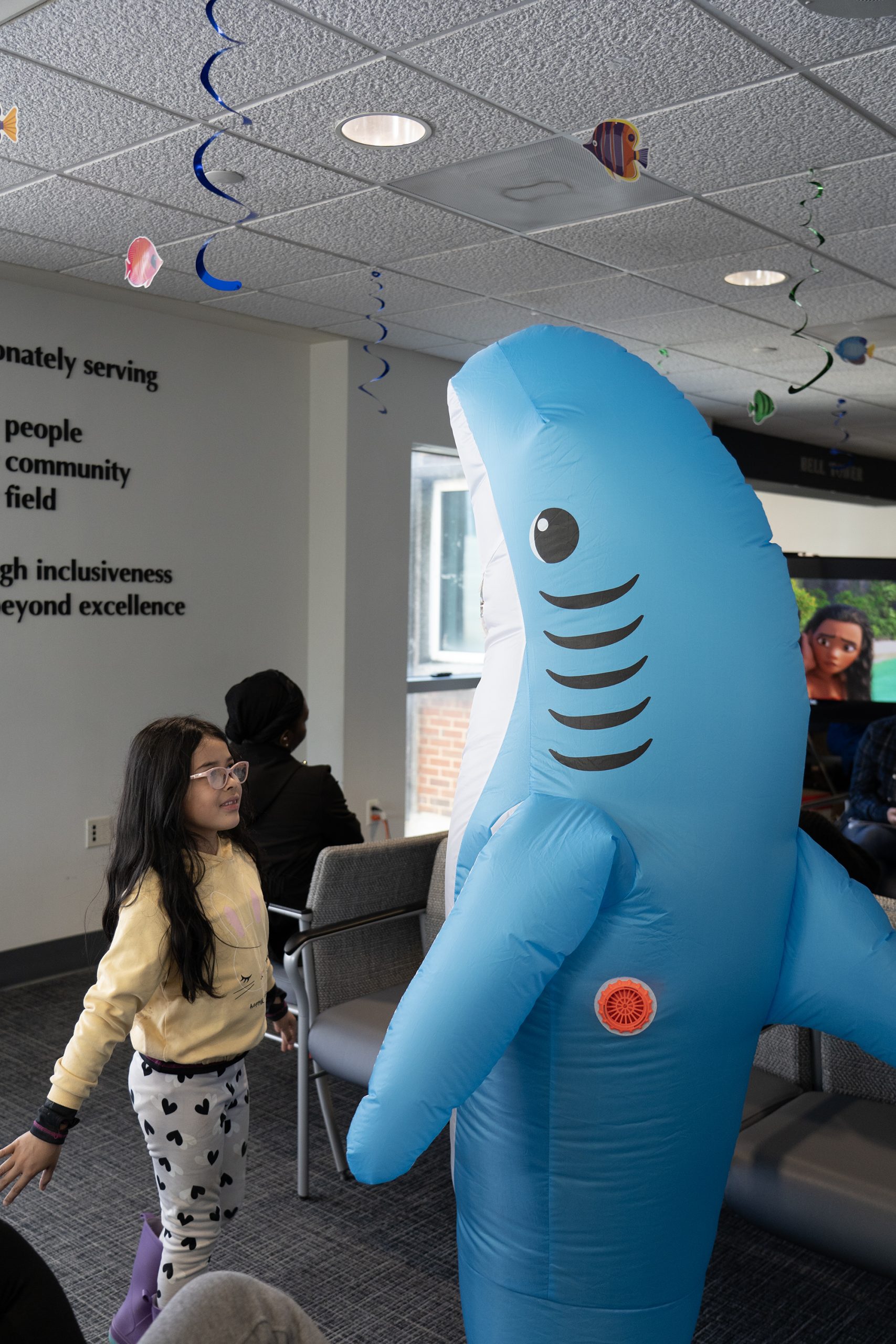 a child interacting with a ASOD student dressed up in a shark costume